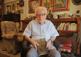 El escritor, decano de los de Granada, con su libro, en su casa de Guadix.