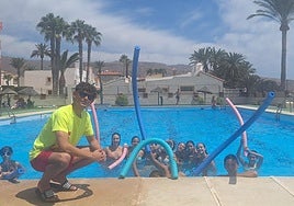 Gabriel Giménez, en la piscina en la que trabaja, acompañado de algunos bañistas.