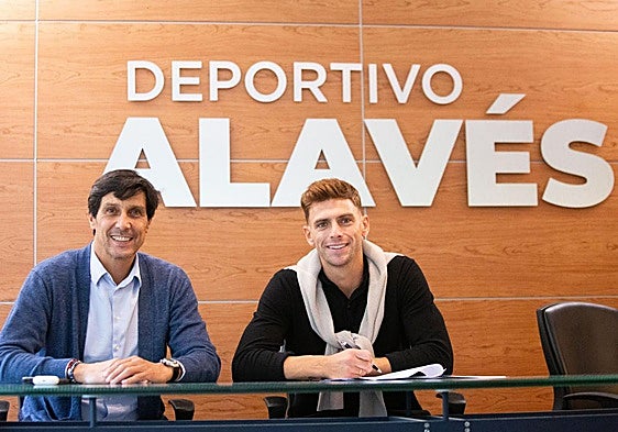 Lucas Boyé firma su contrato con el Alavés junto a su director deportivo, Sergio Fernández.