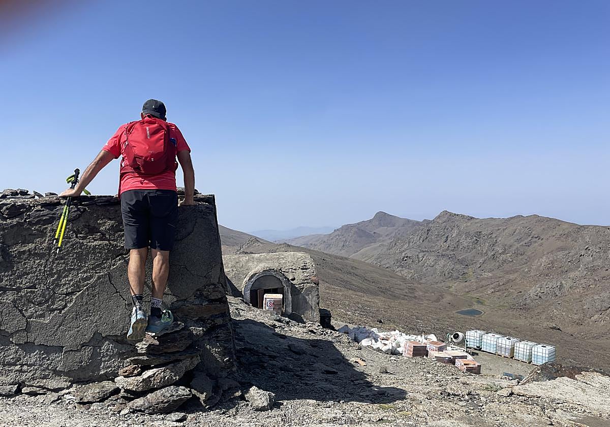 Imagen principal - Un excursionista asomado al aljibe del refugio, el pico del Caballo, a través de la ventana, y cascoques en el suelo del albergue. 