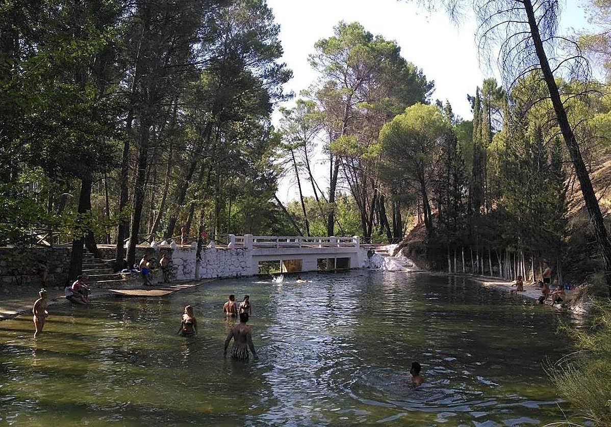Gente bañándose en la piscina natural de Siles.