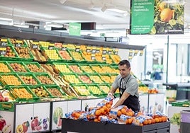 Un trabajador de Mercadona en la seccion de frutas.