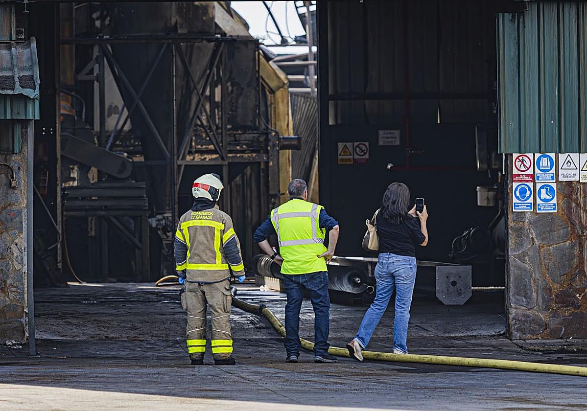 La inspectora de Trabajo, acompañada de bomberos, en la fábrica de aceite de Pinos Puente, nada más ser sofocado el incendio.