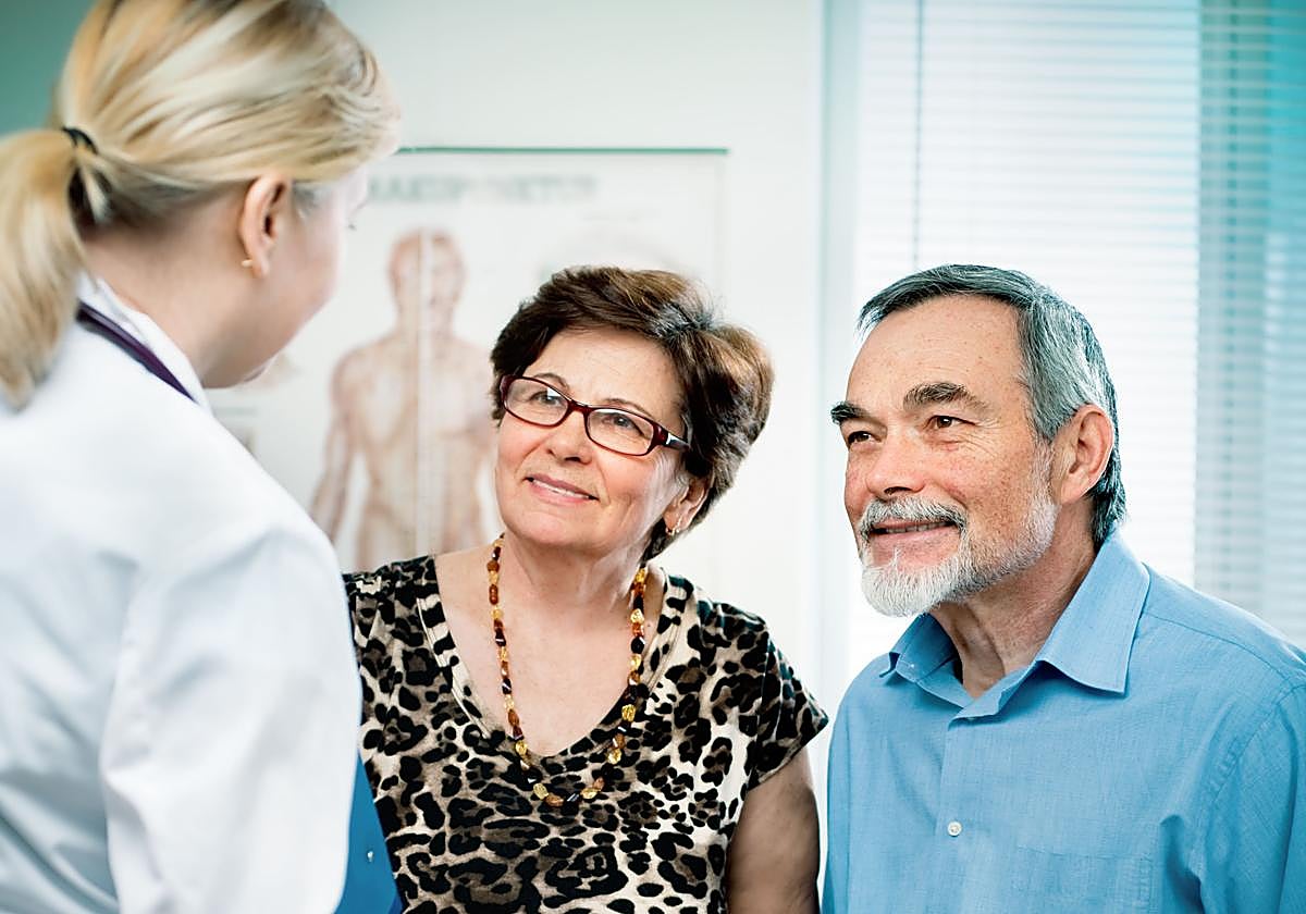 Una pareja de jubilados junto a una médica en consulta.