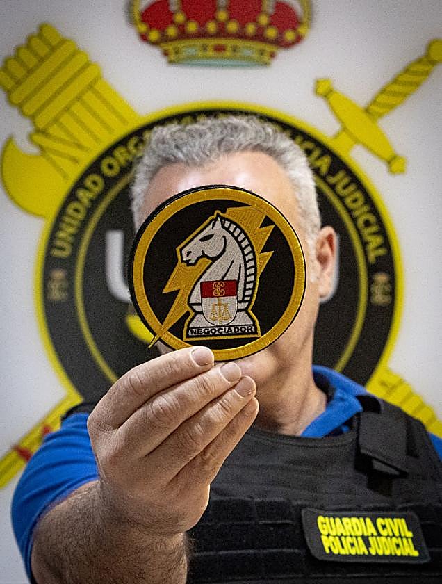 Uno de los dos negociadores de la Guardia Civil sostiene el nuevo escudo, creado recientemente.