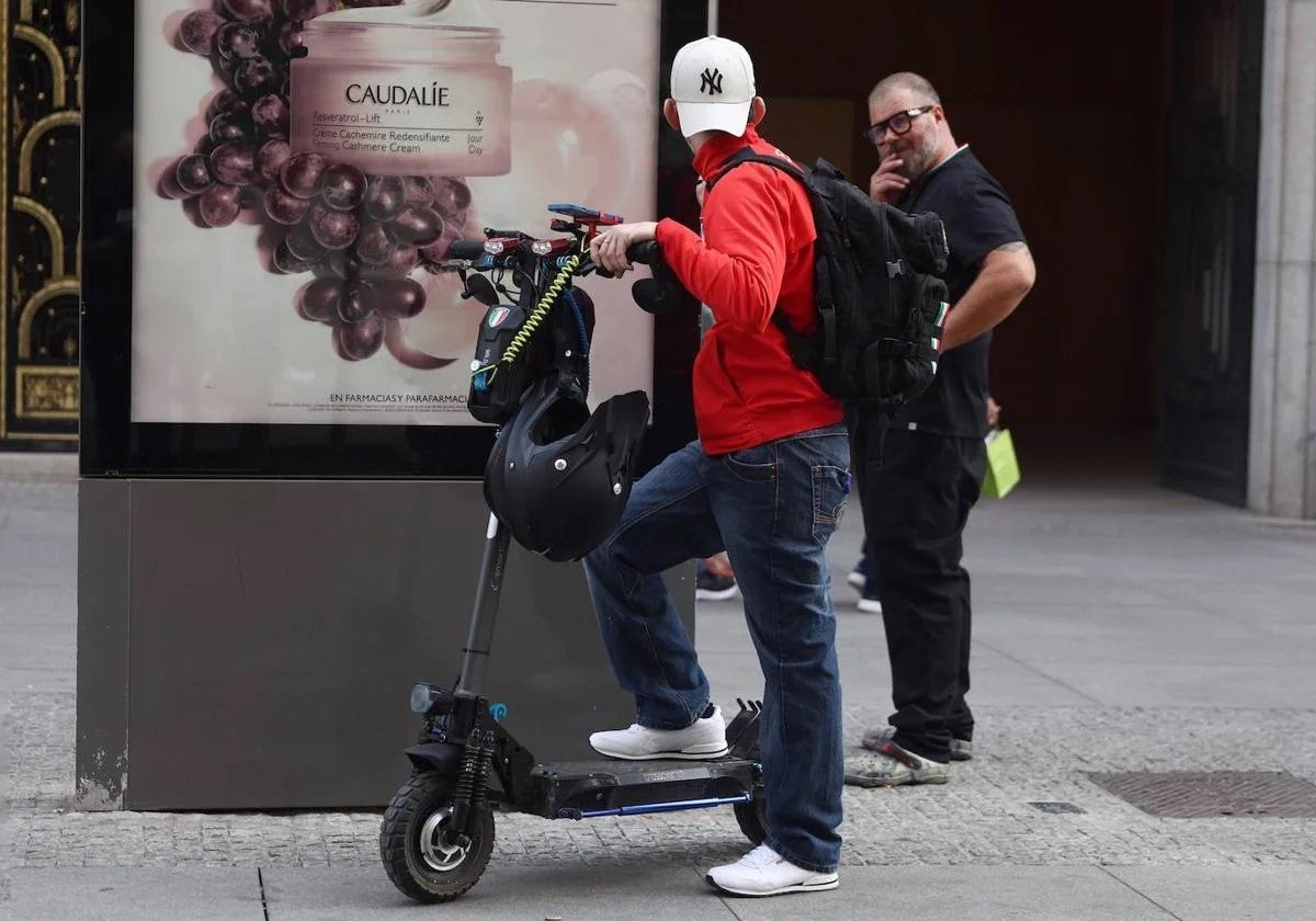 Un hombre en patinete charla con otro antes de iniciar la marcha.