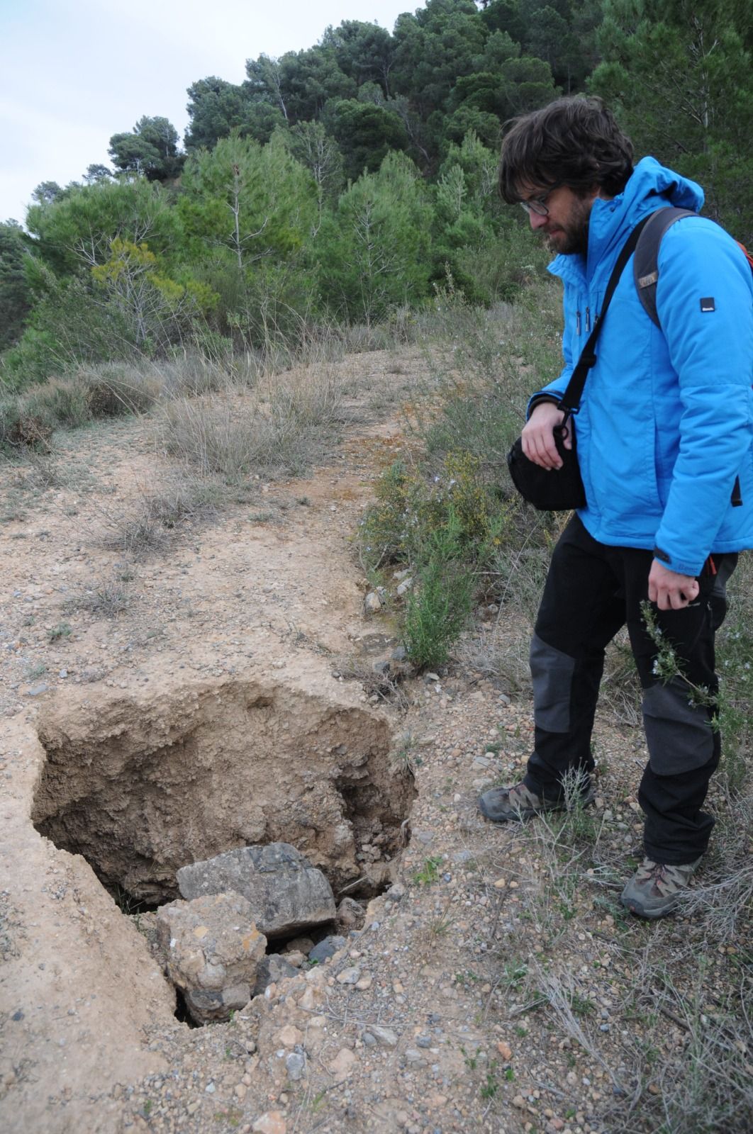 Imagen secundaria 2 - El profesor Jorge Pedro Galve y Cristina Reyes, que hizo la tesis doctoral sobre el tema, observando socavones y grietas en el entorno del viaducto en el año 2019.