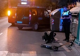 El conductor del patinete yace en el suelo tras el impacto contra el autobús.