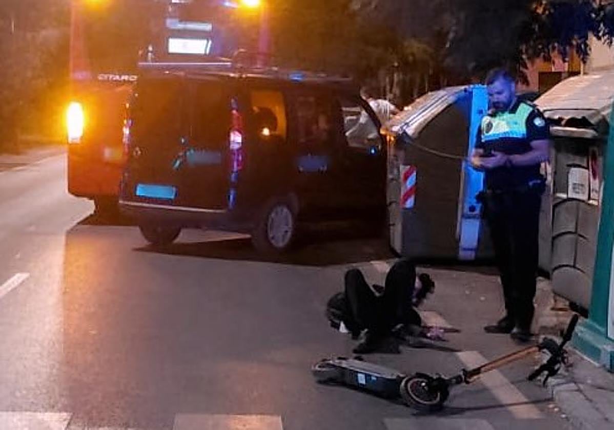 El conductor del patinete yace en el suelo tras el impacto contra el autobús.