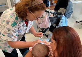 Una enfermera vacuna a un bebé.