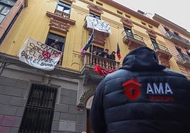 Okupas en el balcón del edificio de Azacayas y, debajo, un trabajador de la empresa granadina de desalojo