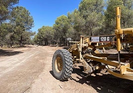 Máquina en uno de los tramos de la pista forestal en obras.