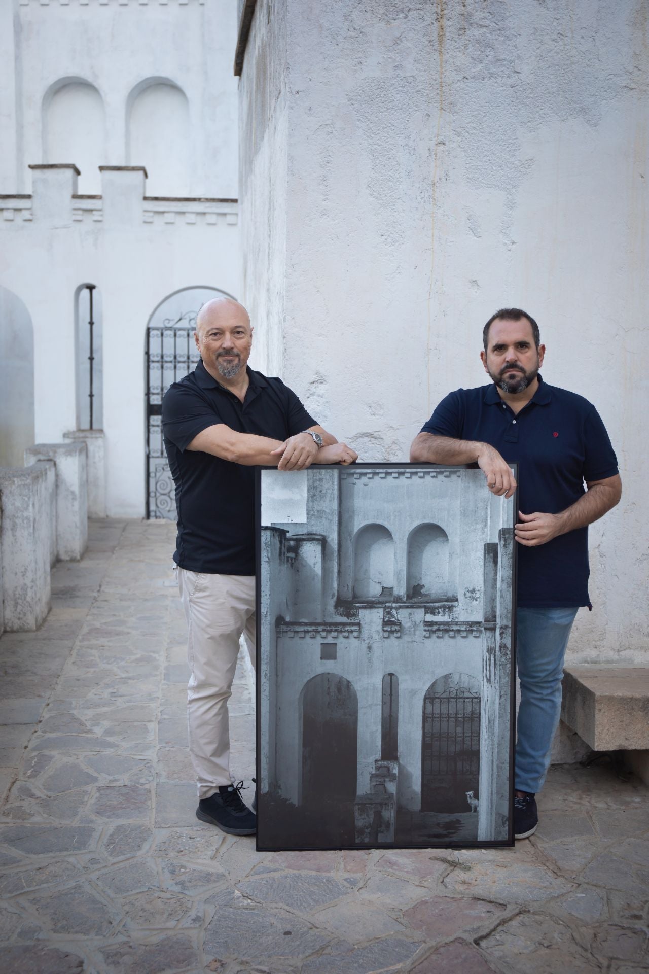 Sánchez Montalbán y Peralbo posan con una foto de la exposición tomada desde el mismo sitio que la hizo Fernández.