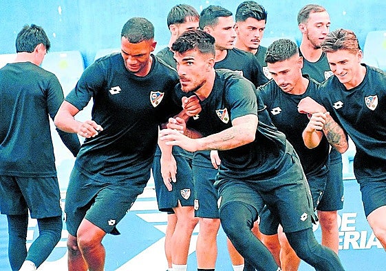 El defensa Manny y el guardameta Barrios en primer plano, haciendo ejercicios en Linarejos.