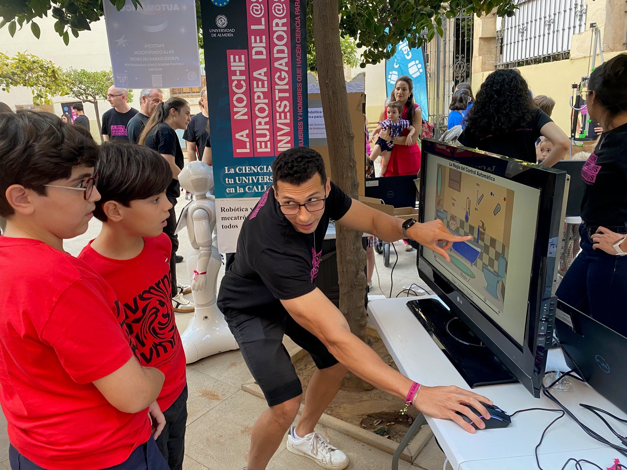 Dos escolares escuchan con atención y sorpresa la explicación de uno de los voluntarios.