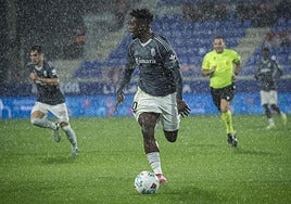 Moha Bouldini conduce un balón bajo la lluvia sobre Huesca durante su reaparición con el Granada.