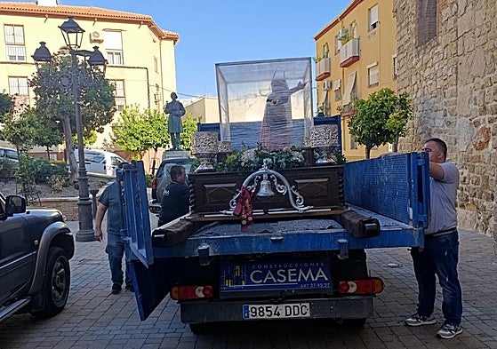 Hermanos de la cofradía de San Juan Bautista de Los Villares preparan la imagen para llevarla de nuevo a su ermita.
