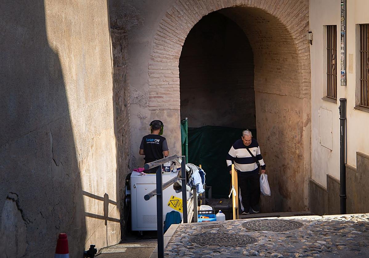 Un operario limpia las pintadas del Arco de las Pesas.