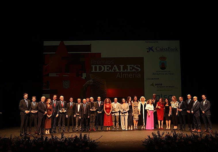 Foto de familia de los premiados, con representantes de IDEAL, autoridades y patrocinadores, en el escenario del Teatro Auditorio de Roquetas de Mar.
