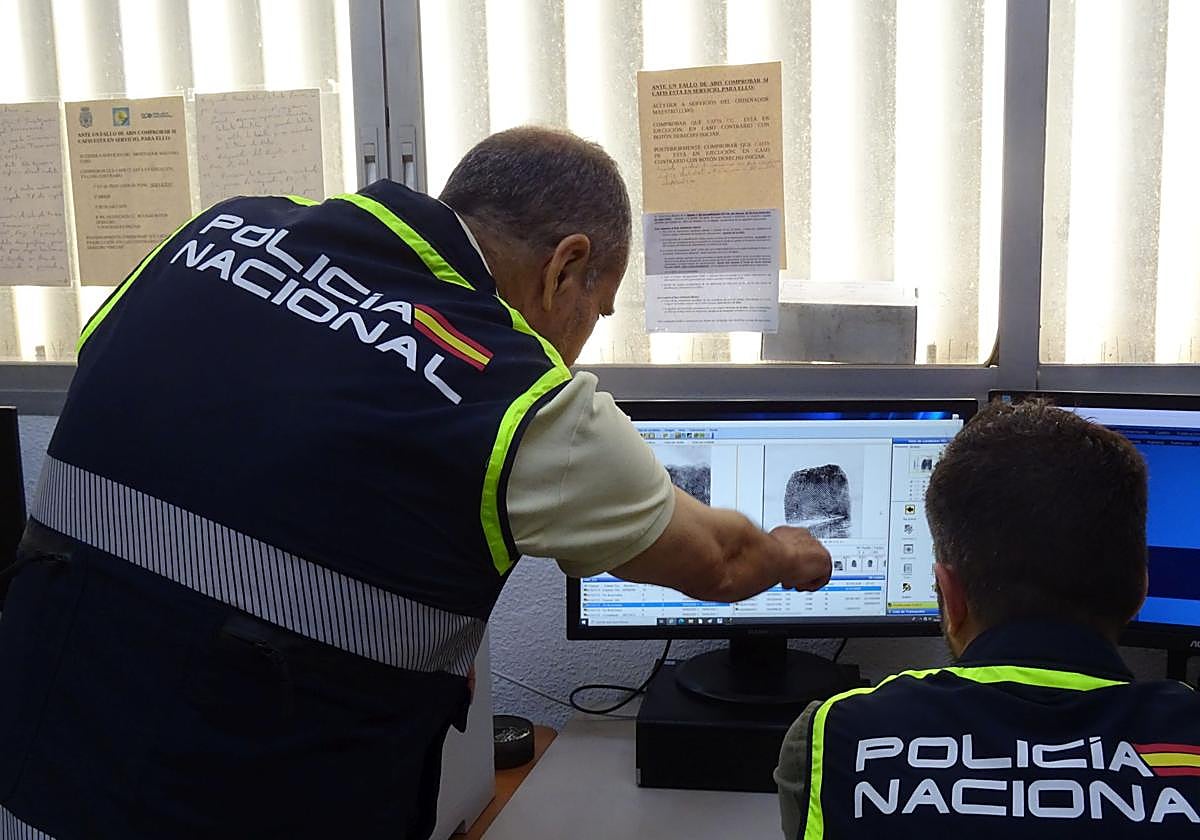 Agentes de Policía Científica en el laboratorio observan algunas huellas en un ordenador.