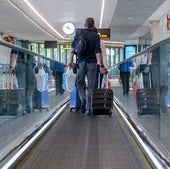 Un viajero, con sus equipaje de mano en un aeropuerto español.