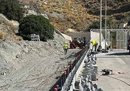 Los operarios trabajan en la contrucción del muro.