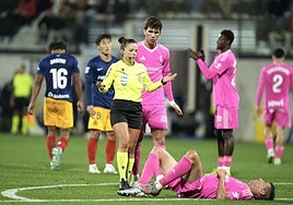 La colegiada Marta Huerta se interesa por un dolido Alcaraz sobre el césped.