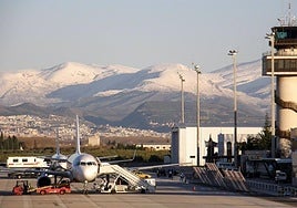 Un avión en el aeropuerto de Granada con Sierra Nevada de fondo.