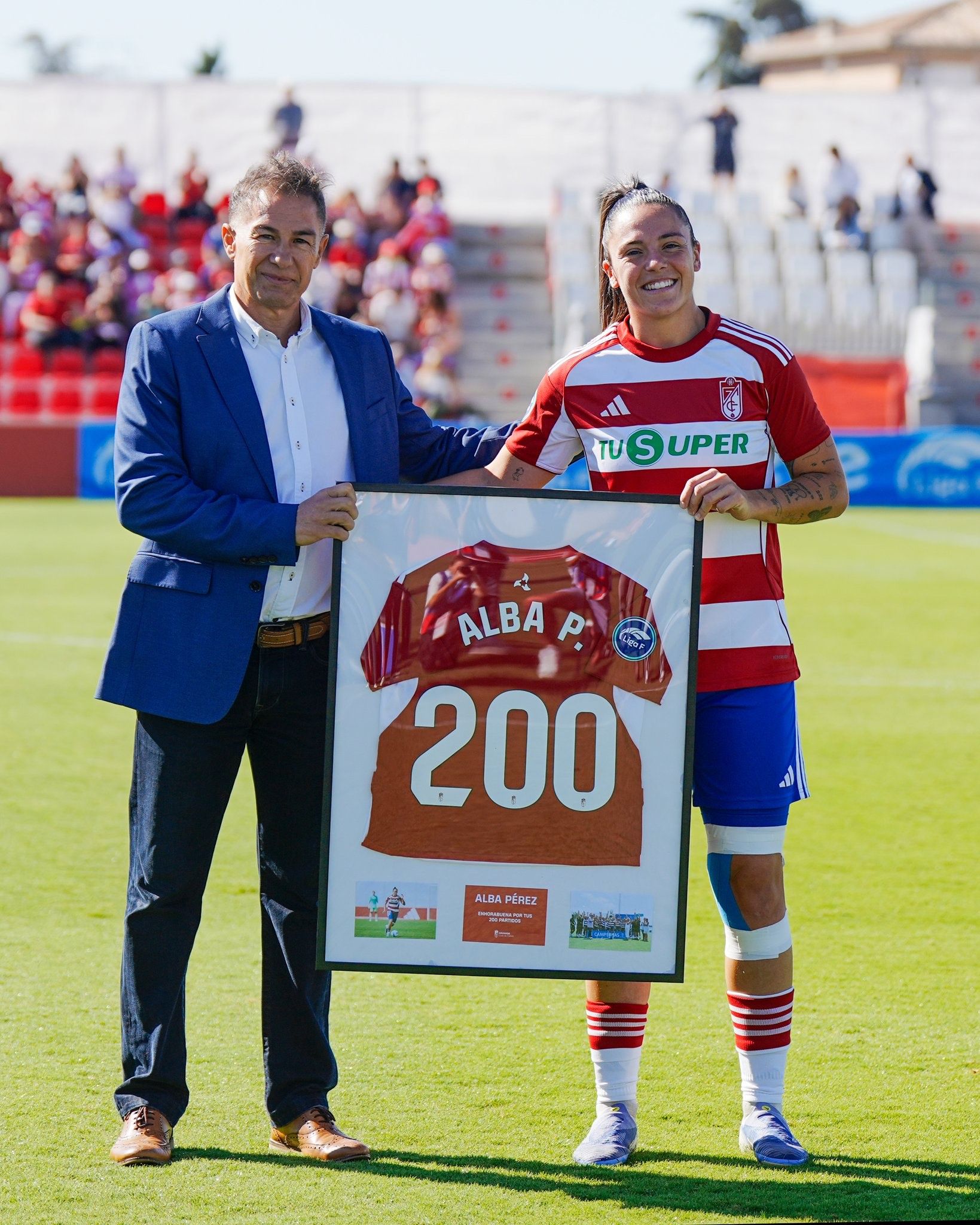 Alba Pérez recibe una camiseta conmemorativa por parte de Roberto Valverde.