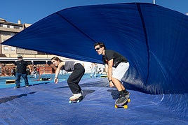 Alumnos surfean una 'ola' en tablas de skate.