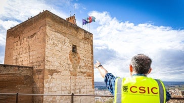 Uno de los responsables del proyecto señala el dron junto a la ventana de la Torre de la Vela.
