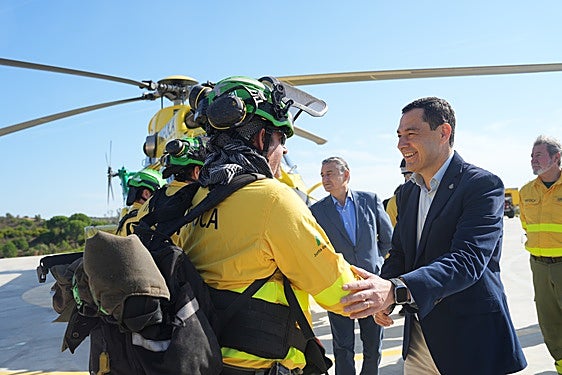 Juanma Moreno saluda a un equipo del Infoca en presencia de Antonio Sanz.