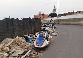 Moto de agua abandonada sobre un montón de plásticos y residuos.