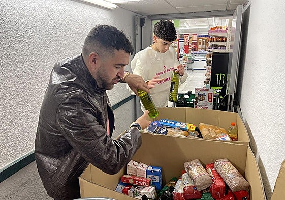 Julián Medina y un voluntario del IES Fuente de la Peña guardan en cajas los alimentos donados.