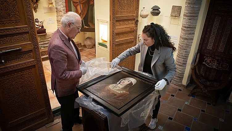 Carlos Ballesta y María Esperanza Pérez desenvuelven el cuadro de Isabel la Católica que ha adquirido la Fundación.