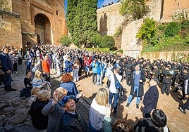 Los granadinos congregados en la Puerta de la Justicia miran hacia el dron que sobrevuela la Alhambra para la foto de familia.