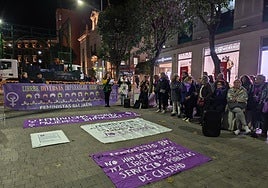 Asistentes a la concentración con motivo del 25-N alrededor de las pancartas reivindicativas.