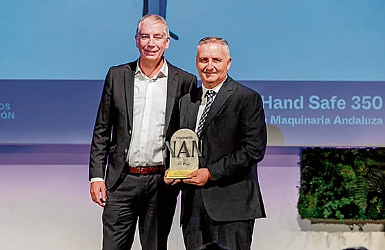 El director general de SIMA, Javier García, recoge su galardón de manos de Yago Hernández.