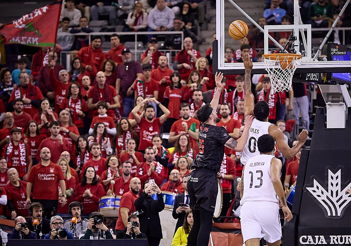 El rojinegro Zach Hankins intenta una penetración ante el merengue Lyles.