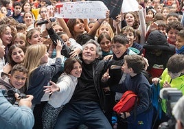 Miguel Ríos, rodeado por un centenar de niños y niñas, en el polideportivo de la Chana.