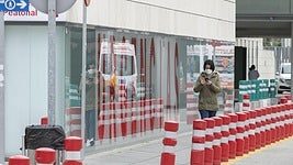 Una mujer con mascarilla en la entrada del Hospital San Cecilio de Granada.