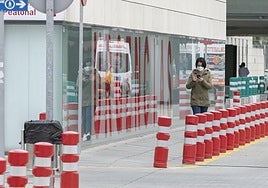Una mujer con mascarilla en la entrada del Hospital San Cecilio de Granada.