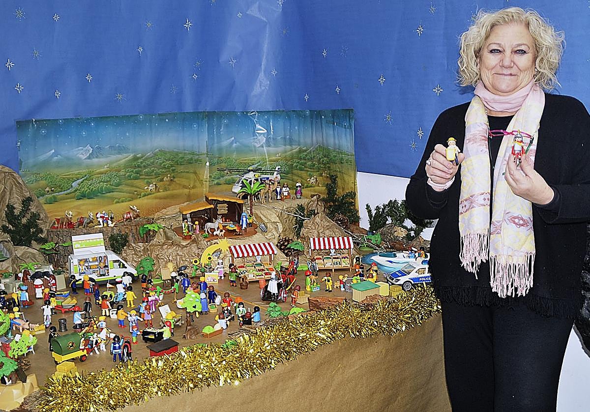 La bibliotecaria de Órgiva, Mari Carmen Martín, terminando de instalar el Belén de Playmobil en el centro que dirige.