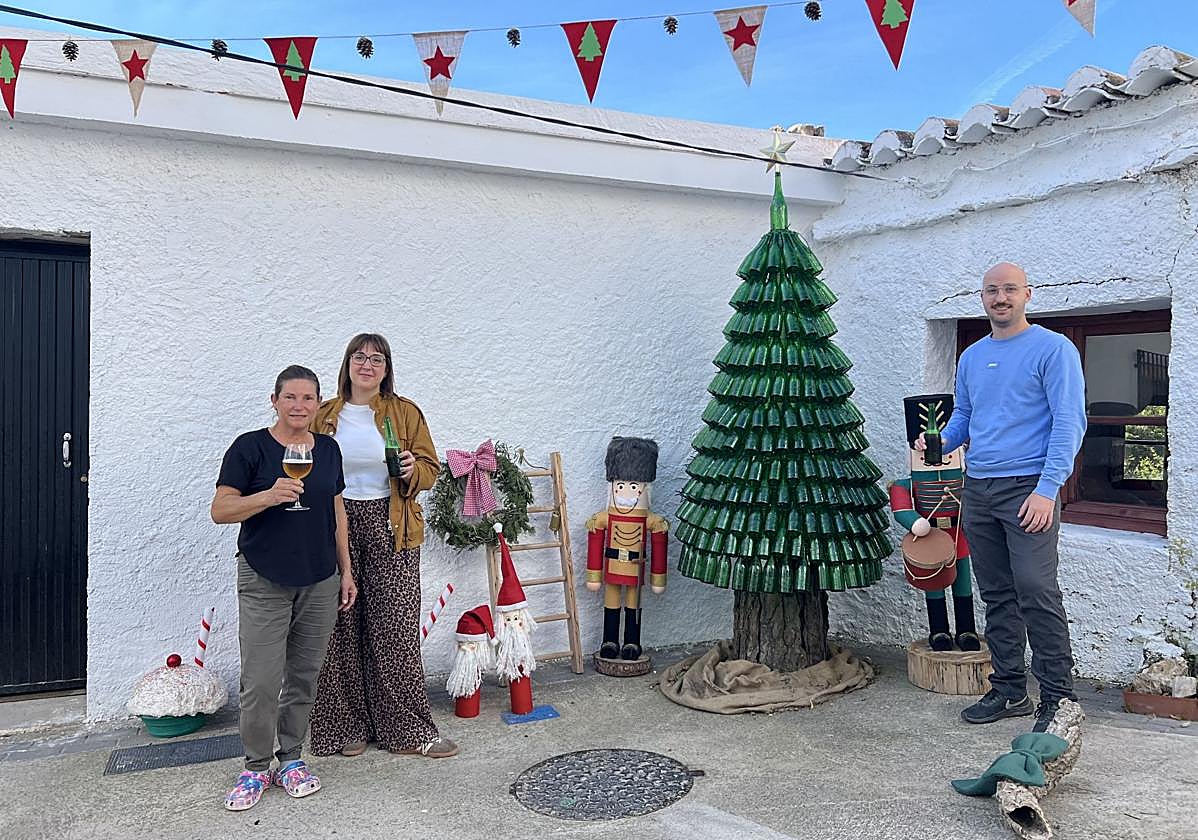 Ana y su familia posan junto al novedoso árbol fabricado con cervezas Alhambra,