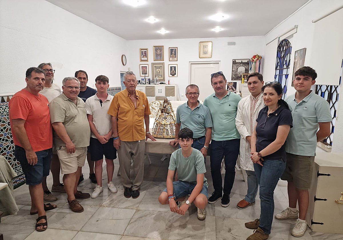 Hermanos de la cofradía junto a la virgen en el taller antequerano.