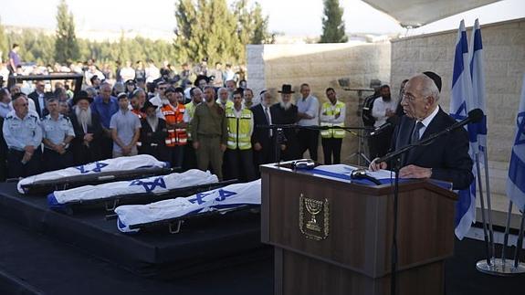 El presidente de Israel, Shimon Peres (d), hablaa durante el funeral colectivo de los tres jóvenes israelíes secuestrados y asesinados