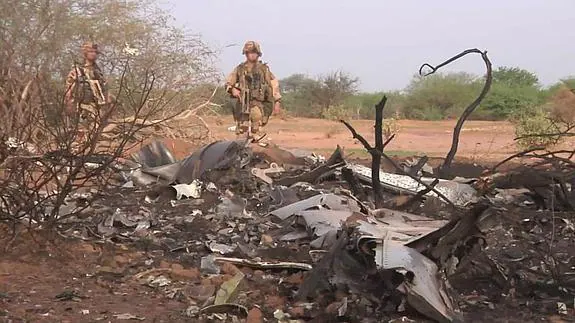 Dos soldados inspeccionan la zona donde fueron encontrados los restos del avión.