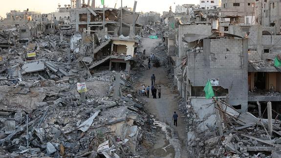Palestinos permanecen en medio de casas destruidas en el barrio de Al Shejaeiya.