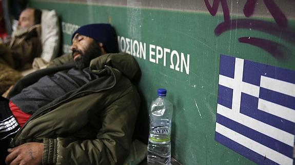 Dos mendigos duermen a la entrada del metro en Atenas. 