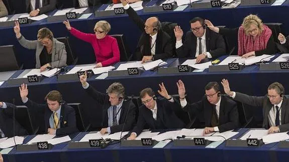 Varios europarlamentarios votan durante el pleno de la Eurocámara. 